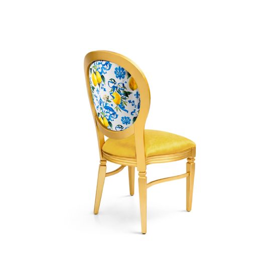 Gold Chandelle chair with oval floral back in blue and yellow tones and yellow upholstered seat, elegant vintage-style banquet chair for weddings and formal events