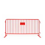 Red metal crowd control barrier with vertical bars and stabilizing feet, portable safety barricade for event lines, restricted areas, and venue security