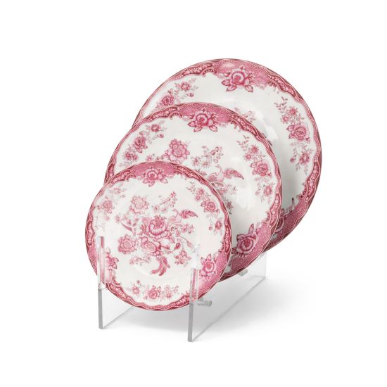 Pink and white floral ceramic dinner plates with ornate vintage pattern and decorative border displayed on stand for elegant table settings