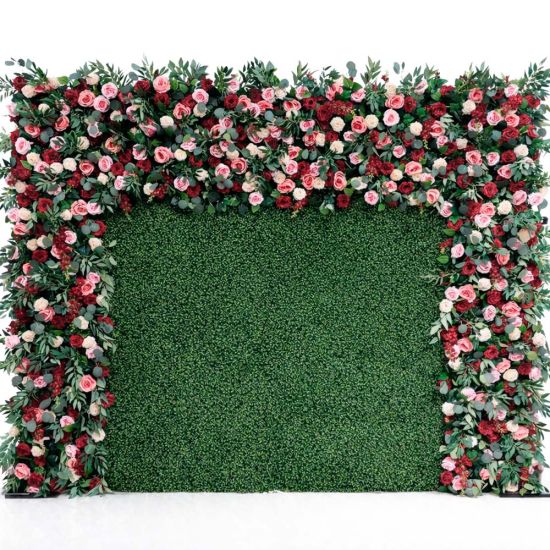Green hedge wall with floral border frame of pink and white blooms, garden-style backdrop panel for weddings and photo booth setups.