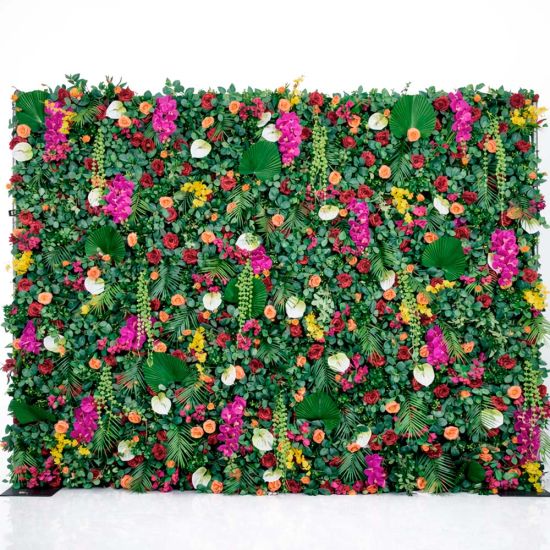 Green foliage wall backdrop with bright mixed flowers and tropical accents, colorful photo backdrop panel for parties and event décor.