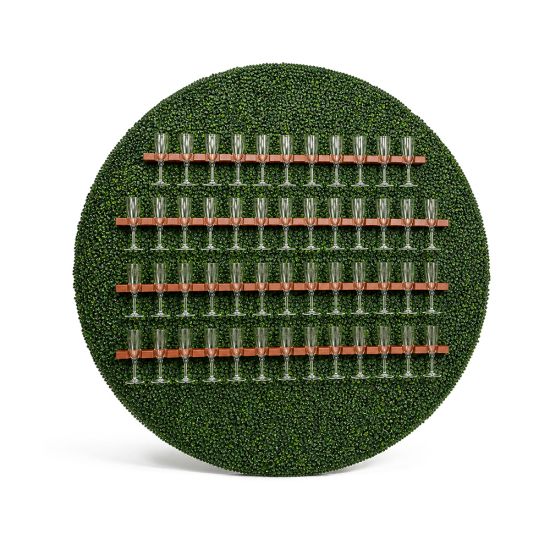 Round green hedge backdrop with horizontal wine glass holder rails, functional bar display wall for weddings, cocktails, and event décor.