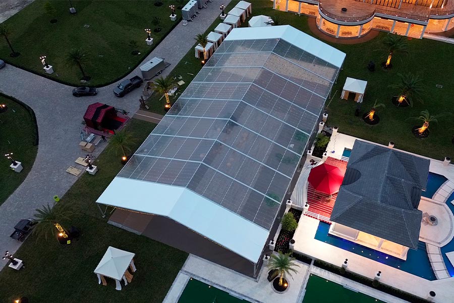 Large clear span wedding marquee with white gables and interior lighting at a luxury estate.