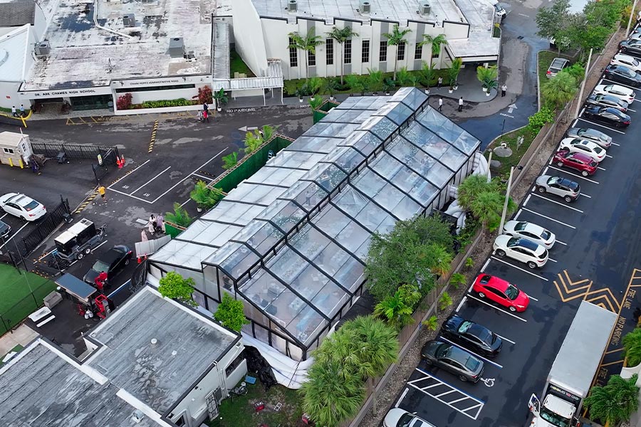 Aerial view of a large clear frame event tent installed in a paved outdoor venue space.