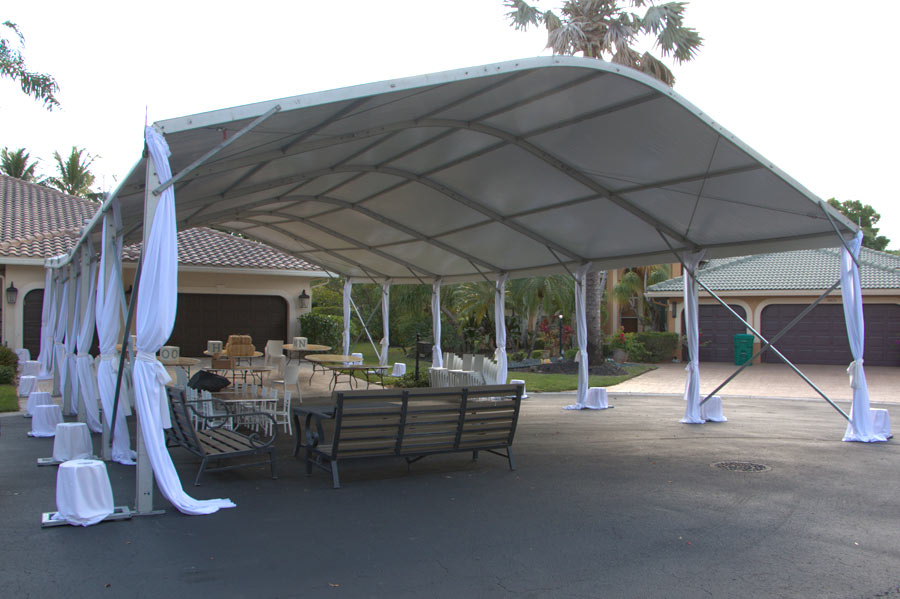 Heavy duty frame tent over tables and chairs, showing the durable metal structure.