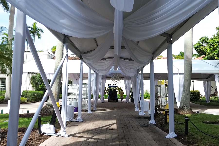 White fabric-draped walkway tent creating shaded entrance for upscale outdoor event.
