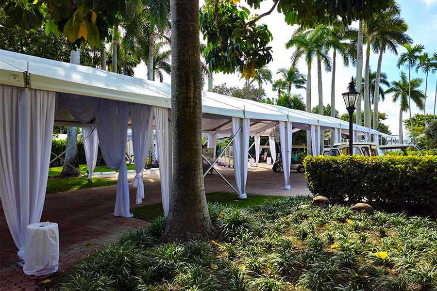Elegant white walkway tent with draped fabric for luxury outdoor event entrance.