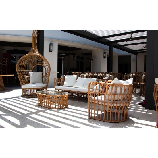 Bohemian single hanging wicker bed with teardrop pod design and cushions, statement lounge rental for boho weddings and events.