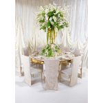 Ivory high-back event chairs with gold legs, featuring embroidered lace and smooth fabric covers with ivory cushioned seats for elegant wedding décor.