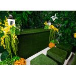 Grass ottoman covered in green artificial turf with cube shape, versatile lounge footrest or seat rental for outdoor events.