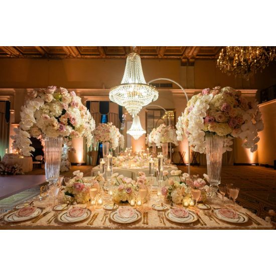 Chandelier hanger and coupler stand wrapped in greenery garland, curved support for hanging chandeliers or floral décor.