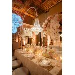Chandelier hanger and coupler stand wrapped in greenery garland, curved support for hanging chandeliers or floral décor.