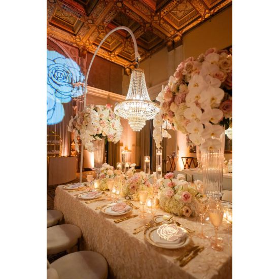 Chandelier hanger and coupler stand wrapped in greenery garland, curved support for hanging chandeliers or floral décor.
