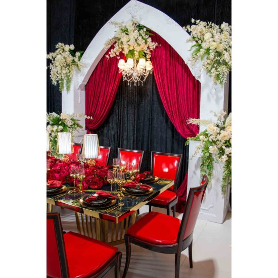 White empire-style arch frame with pointed top, decorative trim, and column bases, statement ceremony arch for weddings and event backdrops.