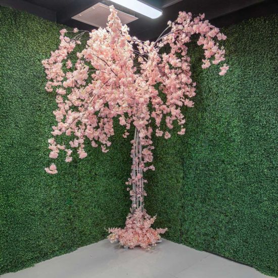 Artificial cherry blossom tree with cascading light pink blooms on a trunk base, statement floral décor for weddings and event photo backdrops.