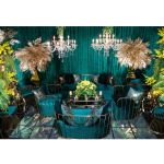 Emerald Green velvet accent loveseat with gold metal bar frame and two black pillows, modern art deco lounge seating for luxury events.