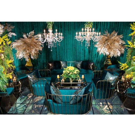 Emerald Green velvet accent loveseat with gold metal bar frame and two black pillows, modern art deco lounge seating for luxury events.