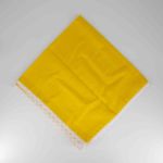 Yellow table napkin with white lace trim detail, neatly folded on a white plate for bright spring weddings and event table settings
