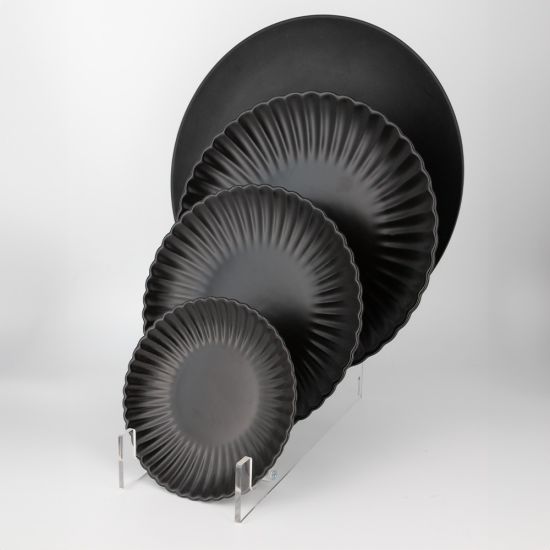 Black petal-rim onyx salad plate with scalloped edge and sunburst ridged design, medium round plate on a white background