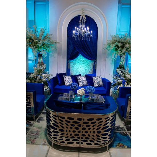 Royal Blue velvet Reflection Giraffe sofa with gold abstract slat metal base and matching pillows, luxury seating for upscale weddings and events.