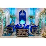 Royal Blue velvet Reflection Giraffe sofa with gold abstract slat metal base and matching pillows, luxury seating for upscale weddings and events.