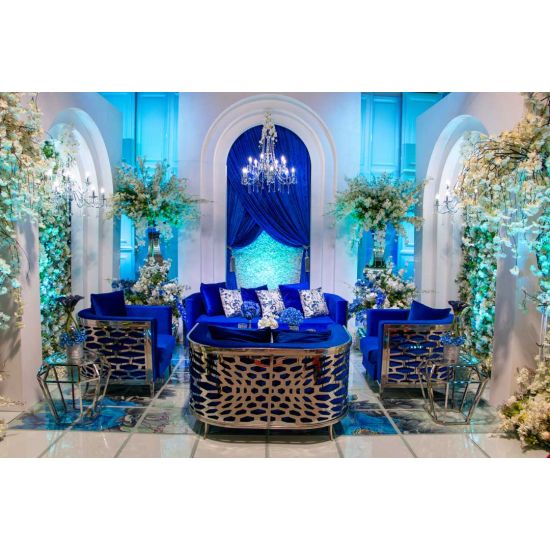 Royal Blue velvet Reflection Giraffe sofa with gold abstract slat metal base and matching pillows, luxury seating for upscale weddings and events.