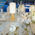 Clear crystal charger plate with thin black rim and smooth glass center, sleek modern charger for weddings and formal event tables