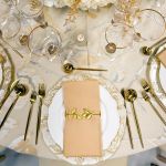 Ivy napkin holder with green faux ivy vine entwined around a metal ring holding a folded white cloth napkin, botanical accent for event tables