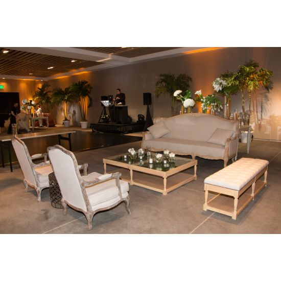 Vintage bench with natural wood frame, tufted white upholstered seat and lower shelf, elegant seating for weddings and events.