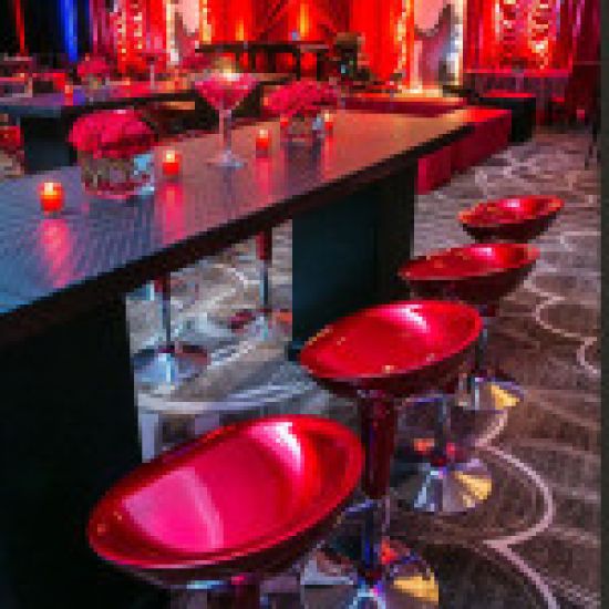 Black scoop-seat adjustable metal bar stool with chrome base and foot-rail, sleek contemporary event bar seating solution