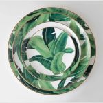 Banana leaf dinner plate with bold green foliage print framing the rim and gold edge, round design on a white background for tropical events