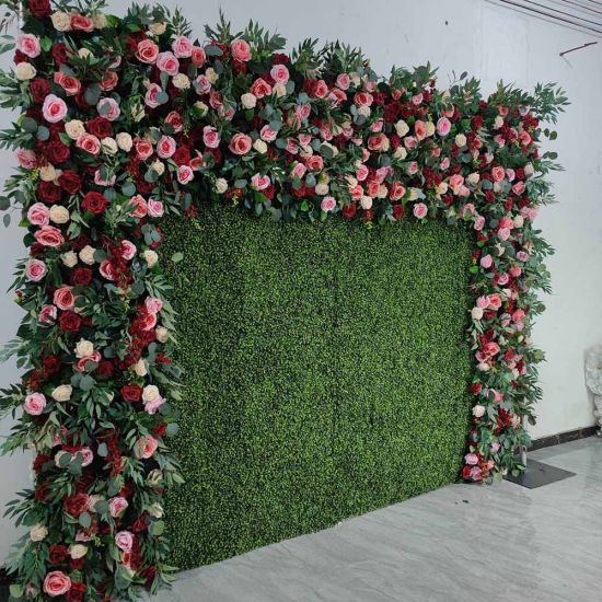 Green hedge wall with floral border frame of pink and white blooms, garden-style backdrop panel for weddings and photo booth setups.