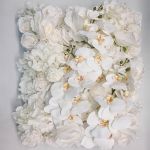 White orchid-style flower wall backdrop with dense blooms, elegant wedding photo backdrop panel for ceremonies and event décor styling.