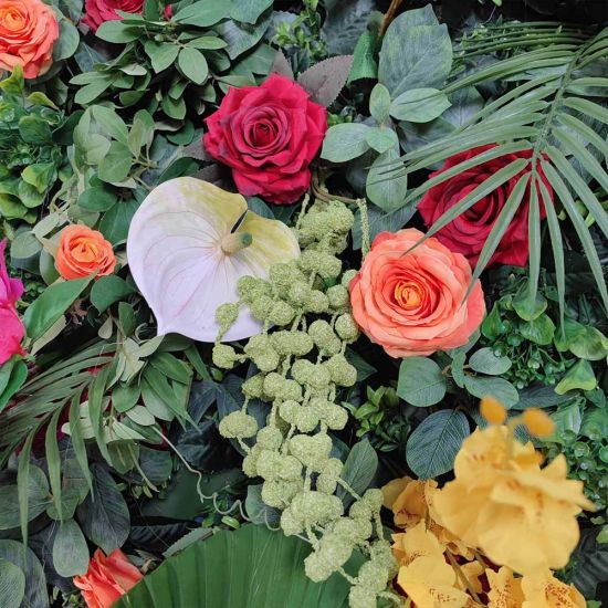 Green foliage wall backdrop with bright mixed flowers and tropical accents, colorful photo backdrop panel for parties and event décor.