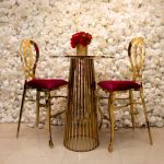 Gold Halexandria bar stool with Hot Pink cushioned seat and curved metal backrest on bar-height frame with foot-rail