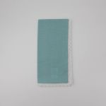Aqua table napkin with white lace trim detail, neatly folded on a white plate for elegant weddings and formal event table settings