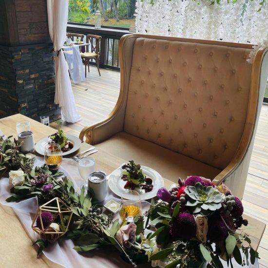 Empire loveseat in gold with tall wingback and button-tufted upholstery, statement lounge seating rental for weddings and events.