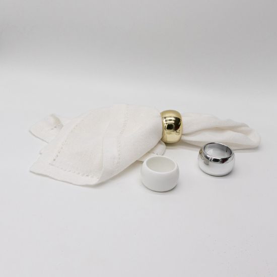 Set of basic napkin rings in gold, silver, and white finishes holding folded white cloth napkins, versatile table accessory for weddings and events