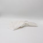 Large crystal cut napkin ring with faceted clear design holding a folded white cloth napkin, glamorous table accessory for wedding and formal event place settings