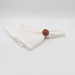 Red stone napkin ring with metallic band and faceted red gemstone detail securing a folded white cloth napkin, elegant accent for event tables