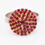 Red stone napkin ring with metallic band and faceted red gemstone detail securing a folded white cloth napkin, elegant accent for event tables