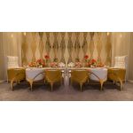 Gold trident accent armchair with smooth upholstery, curved back, gold-trim side cutouts, and sleek gold metal legs for luxury event lounge seating.