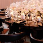 Reflection Serpentine black table with curved black top and black legs, modern serpentine dining table design for luxury event rentals and décor.