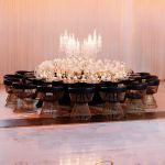 Reflection Serpentine black table with curved black top and black legs, modern serpentine dining table design for luxury event rentals and décor.