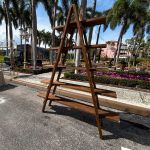 Black metal ladder-style shelving unit with warm natural wood shelves Rustic Wood Ladder for event bar and lounge display